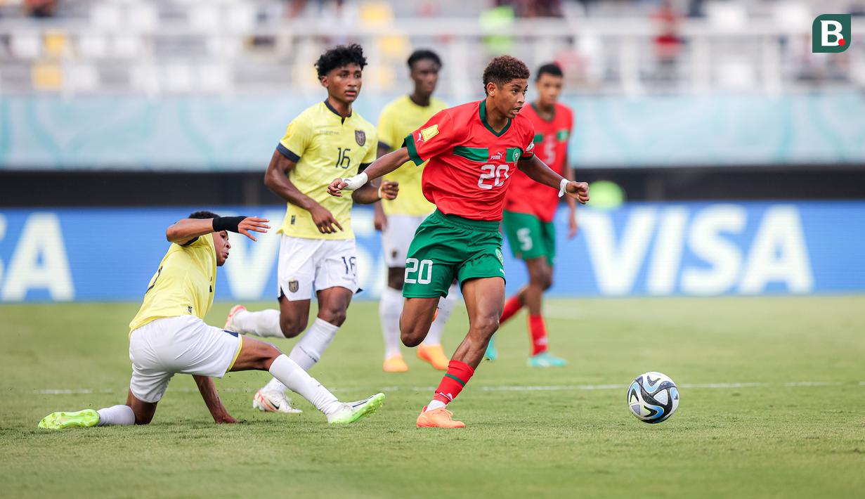 <p>Pemain Timnas Maroko U-17, Mohamed Amine Katiba (kanan) menggiring bola melewati dua pemain Timnas Ekuador U-17 pada laga kedua Grup A Piala Dunia U-17 2023 di Stadion Gelora Bung Tomo (GBT), Surabaya, Senin (13/11/2023). (Bola.com/Bagaskara Lazuardi)</p>