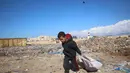Data Kementerian Kesehatan Palestina di Gaza, pada Rabu (20/11/2024), mengungkap setidaknya 17.400 anak-anak menjadi korban serangan Israel. Tampak dalam foto, seorang anak laki-laki Palestina mengumpulkan barang-barang yang ia temukan di tumpukan sampah yang dapat digunakan kembali di kota Khan Yunis, Jalur Gaza selatan pada 19 November 2024 (Eyad BABA/AFP)