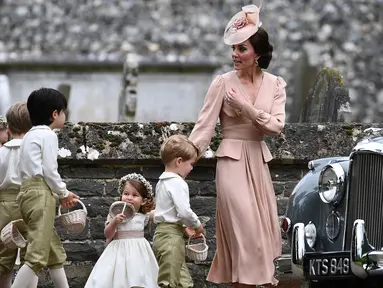 Kate Middleton bersama anak-anak pengiring pengantin menuju lokasi pernikahan sang adik, Pippa Middleton dan James Mathews di Gereja St. Mark, barat London, Sabtu (20/5). Kate Middleton memilih tampil dengan gaun blush pink. (Justin TALLIS/Pool/AFP)
