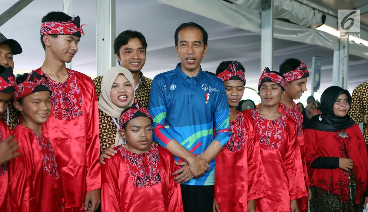 Presiden Joko Widodo atau Jokowi foto bersama penyandang disabilitas saat menghadiri peringatan Hari Disabilitas Internasional 2018 di Bekasi, Jawa Barat, Senin (3/12). (Liputan6 com/Angga Yuniar)