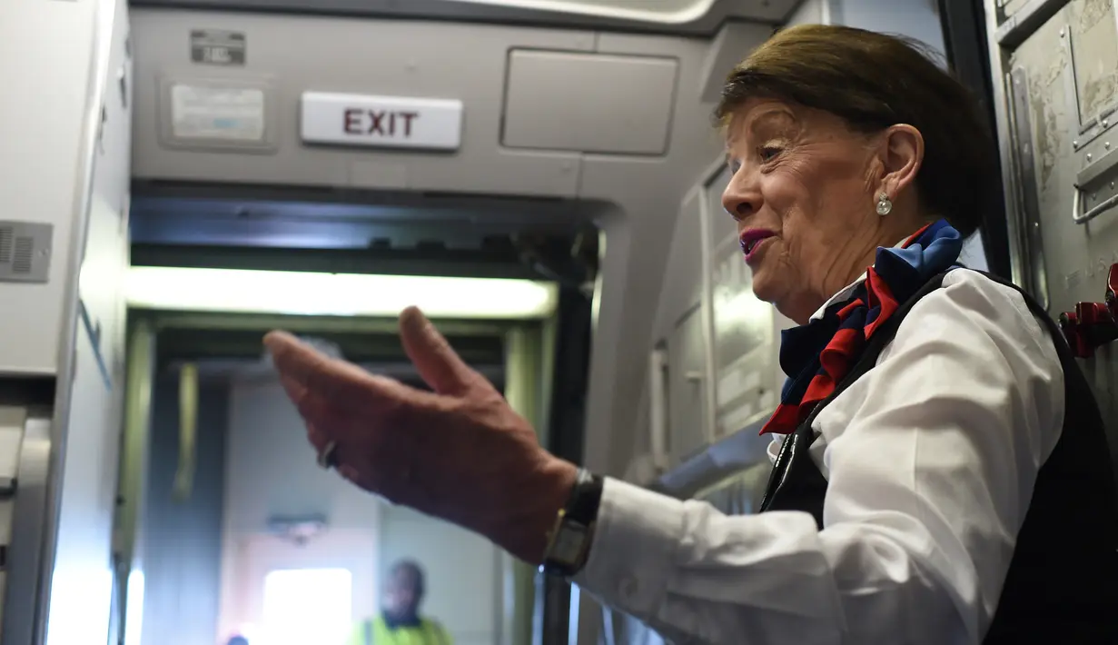 Pramugari Bette Nash menyapa penumpang sebelum melakukan penerbangan ke Boston di Bandara Ronald Reagan Washington di Arlington, Virginia (19/21). Bette Nash adalah pramugari tertua di maskapai American Airlines. (AFP Photo/Eric Baradat)