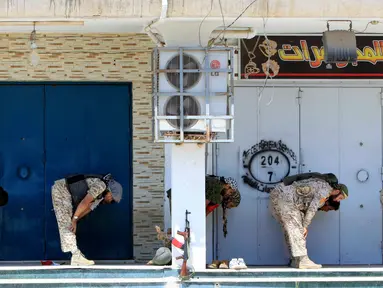 Sejumlah pasukan Libya melakukan salat sebelum mereka mempersiapkan diri untuk berperang melawan militan ISIS di Sirte, Libya (29/8). Dengan kondisi seadanya, mereka tak meninggalkan rukun Islam kedua itu. (REUTERS/Ismail Zitouni)