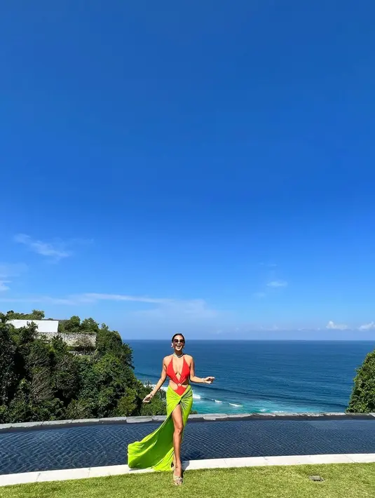 Selain dress, Indah juga kerap mengenakan bikini two piece warna neon dan bold saat liburan di pantai. @indahkalalo.