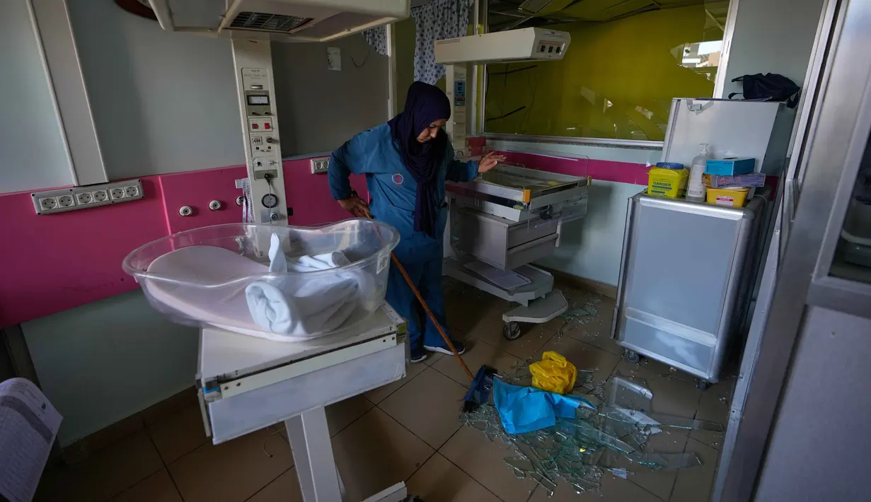 Seorang pekerja mengeluarkan pecahan kaca dari ruang perawatan di Rumah Sakit Jabal Amel yang rusak, setelah serangan udara Israel pada Senin (1/6) yang menghantam gedung di dekatnya, di kota pelabuhan selatan Tyre, Lebanon, Selasa 2 Juni 2026. (AP Photo/Mohammed Zaatari)
