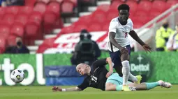 Pemain Inggris Bukayo Saka (kanan) dan memperebutkan bola dengan pemain Austria Xaver Schlager pada pertandingan persahabatan di Stadion Riverside, Middlesbrough, Inggris, Rabu (2/6/2021). Inggris mengalahkan Austria dengan skor 1-0. (AP Photo/Scott Heppell, Pool)