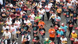 Pramusaji dari berbagai restoran berpartisipasi dalam Waiters Race ke-16 di Antigua, barat daya Ibu Kota Guatemala City, Rabu (14/11). Ratusan peserta beradu kecepatan sembari membawa nampan berisi dua minuman ringan, bir dan air. (JOHAN ORDONEZ/AFP)