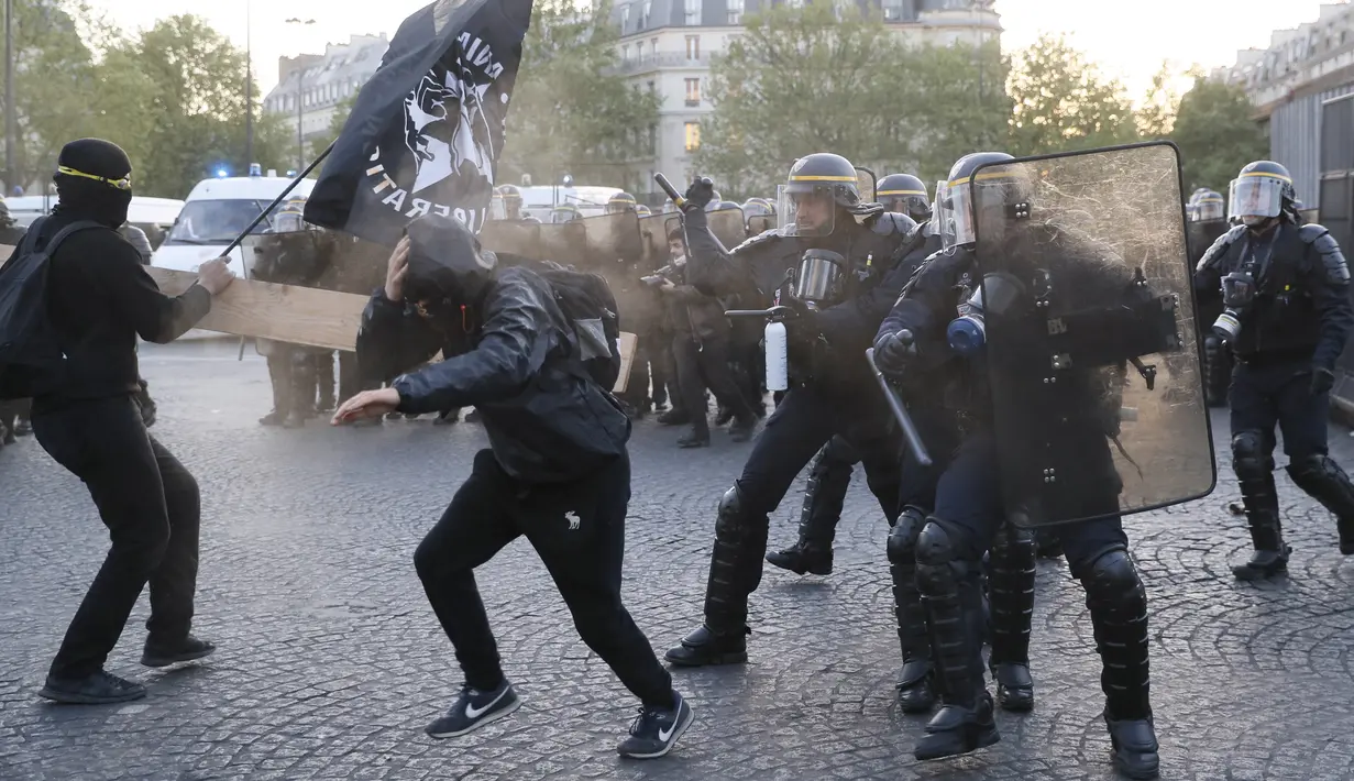 Bentrokan antara demonstran anti-fasis dengan pasukan anti-huru hara yang terjadi saat demonstran menggelar aksinya di Paris (23/4). Mereka melakukan demo untuk menentang Le Pan dan kebijakan anti imigrasinya. (AFP/Thomas Samson)