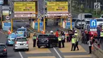 Petugas mengarahkan kendaraan berplat genap berputar balik di Gerbang Tol Bekasi Barat 1, Bekasi, Jawa Barat, Selasa (13/3). Hari kedua penerapan ganjil genap, masih banyak kendaraan berputar balik di gerbang tol tersebut. (Liputan6.com/Arya Manggala)
