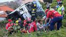 Petugas memberikan pertolongan kepada korban kecelakaan sebuah bus pariwisata di Kota Canico, Pulau Madeira, Portugal, Rabu (17/4). Menurut pejabat perlindungan sipil regional, para turis korban kecelakaan berusia antara 40 hingga 50 tahun. (RUI SILVA / AFP)