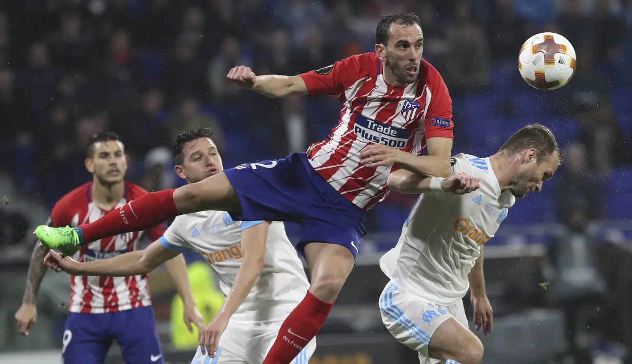 Bek Atletico Madrid, Diego Godin, duel udara dengan pemain Marseille pada laga final Liga Europa di Stadion Groupama, Lyon, Kamis (17/5/2018). Atletico Madrid menang 3-0 atas Marseille. (AP/Laurent Cipriani)