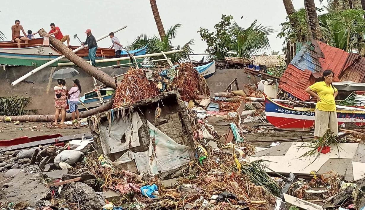 Penduduk mengecek kerusakan akibat hujan lebat dan banjir di Kota Oroquieta, Misamis Occidental (27/12/2022). Korban tewas akibat banjir di Filipina telah meningkat menjadi 25 orang, kata para pejabat pada 28 Desember, dengan badai diperkirakan akan menurunkan lebih banyak hujan di wilayah selatan dan tengah yang paling terpukul. (Photo by Handout/Angelica Villarta/AFP)