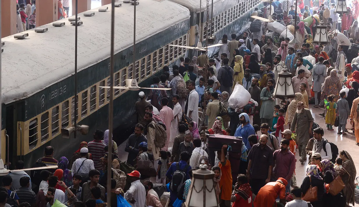 Orang-orang bersiap menaiki kereta untuk melakukan perjalanan pulang untuk merayakan Idul Fitri di sebuah stasiun kereta api di Lahore (2/6/2019). Muslim di seluruh dunia bersiap untuk merayakan Idul Fitri yang menandai akhir bulan puasa Ramadan. (AFP Photo/Arif Ali)