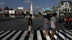 Warga melintas di sekitar perempatan Tugu Pal Putih Yogyakarta, Sabtu (26/12/2020). Proses penataan kawasan Tugu Pal Putih Yogyakarta telah rampung dilakukan, dan kini area yang menjadi salah satu ikon kota Yogya terlihat lebih rapi dan indah tanpa kabel melintang. (Liputan6.com/Helmi Fithriansyah)