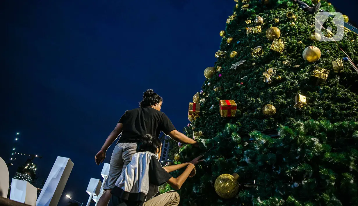 Pekerja menyelesaikan pembuatan Pohon Natal di Thamrin 10, Jakarta, Selasa (22/12/2020). Pemprov DKI mendirikan pohon Natal setinggi 12 meter di Thamrin 10 untuk memeriahkan suasana Natal. (Liputan6.com/Faizal Fanani)