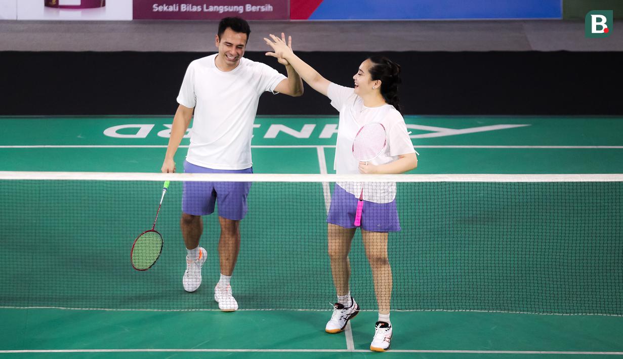 Pasangan selebritas Raffi Ahmad dan Nagita Slavina melakukan tos saat bertanding melawan pasangan Rizky Billar dan Lesti Kejora pada laga bulu tangkis ganda campuran Turnamen Olahraga Selebriti Indonesia (TOSI) di GOR UNJ, Jakarta, Minggu (16/07/2023). Raffi dan Gigi kalah dua set langsung dari Rizky Billar dan Lesti dengan skor 12-21, 10-21.(Bola.com/Bagaskara Lazuardi)