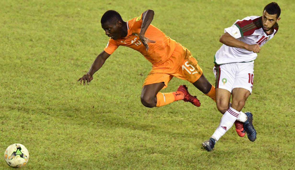 Gelandang Maroko, Younes Belhanda, berebut bola dengan gelandang Pantai Gading, Max Gradel, pada Kualifikasi Piala Dunia 2018 di Stadion Félix Houphouët-Boigny, Abidjan, Sabtu (11/11/2017). Pantai Gading kalah 0-2 dari Maroko. (AFP/Issouf Sanogo)