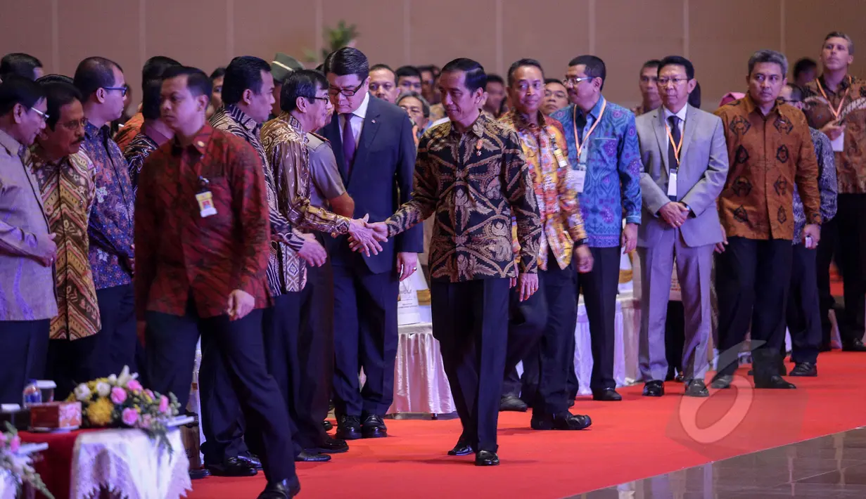 Presiden Jokowi bersalaman dengan Menkumham Yasonna Laoly saat menghadiri pembukaan Asosiasi Pemerintah Kabupaten Seluruh Indonesia (APKASI) International Trade and Investment Summit 2015 di Jakarta, Rabu (13/5). (Liputan6.com/Faizal Fanani) 