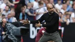 Pelatih Manchester City, Pep Guardiola, memberikan instruksi saat melawan West Ham pada laga Premier League di Stadion London, London, Sabtu (10/8). West Ham kalah 0-5 dari City. (AFP/Ian Kington)