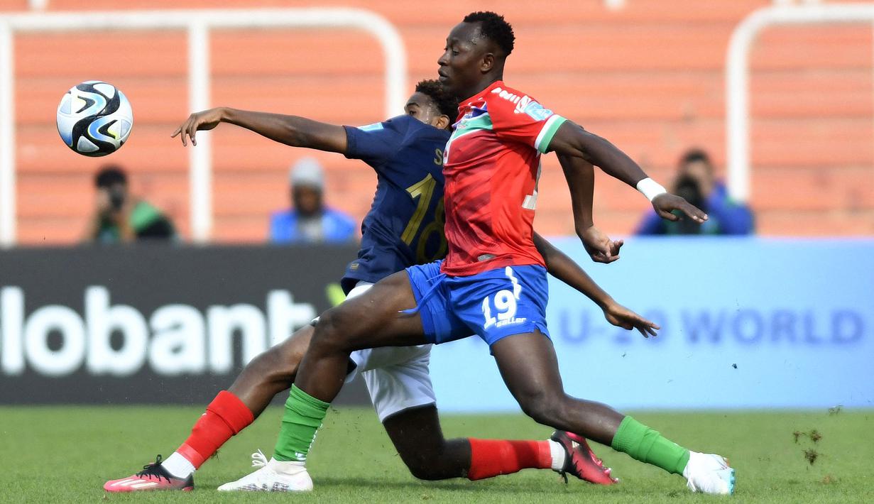 Pemain Prancis U-20, Jordan Semedo Varela (belakang) berebut bola dengan pemain Gambia U-20, Ebrima Singhateh pada laga lanjutan Grup F Piala Dunia U-20 2023 di Stadion Malvinas, Argentina, Jumat (26/05/2023) WIB. Laga berakhir dengan skor 2-1 untuk kemenangan Gambia. (AFP/Andres Larrovere)