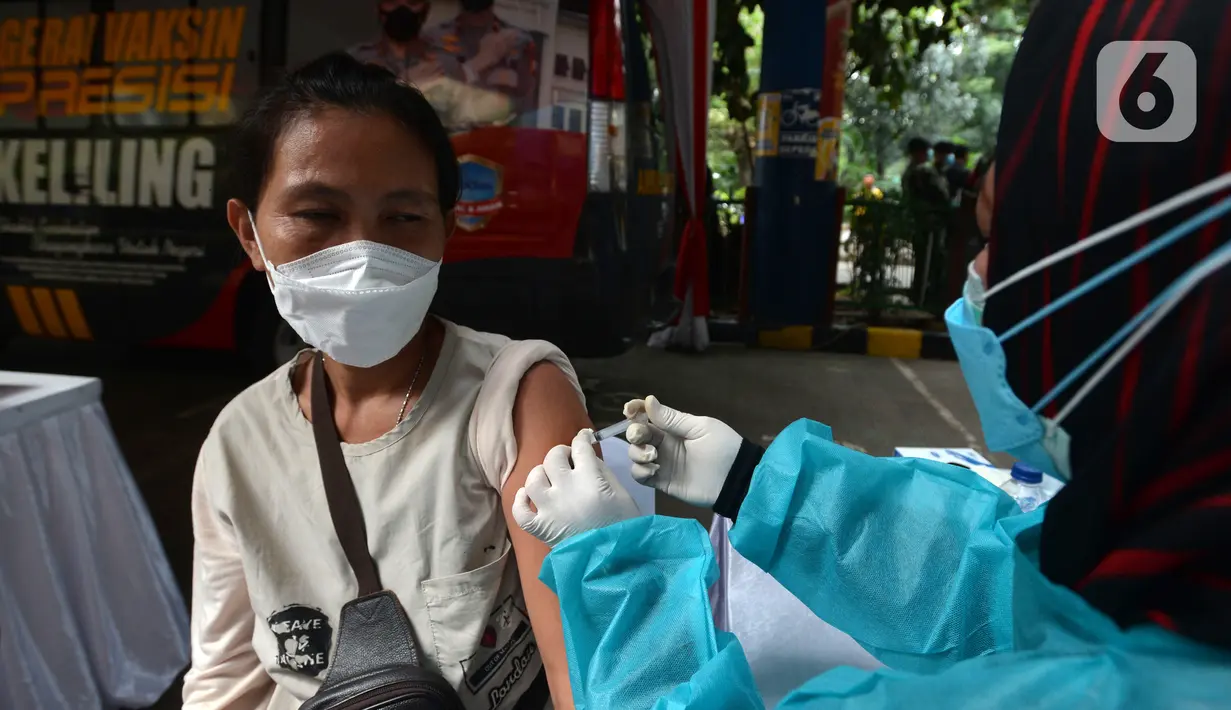 Pedagang disuntik vaksin virus corona COVID-19 di Pasar Induk Kramat Jati, Jakarta Timur, Kamis (22/7/2021). Sebanyak 250 pedagang Pasar Induk Kramat Jati menjalani vaksinasi guna menekan penyebaran COVID-19. (merdeka.com/Imam Buhori)