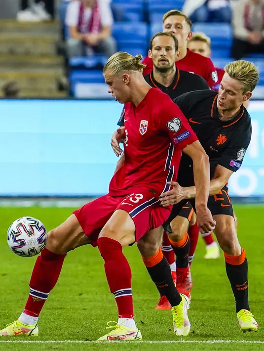 Pemain Norwegia Erling Braut Haaland (kiri) berebut bola dengan pemain Belanda Frenkie de Jong pada pertandingan kualifikasi Piala Dunia 2022 di Stadion Ullevaal, Oslo, Norwegia, Rabu (1/9/2021). Pertandingan berakhir dengan skor 1-1. (Terje Bendiksby/NTB via AP)