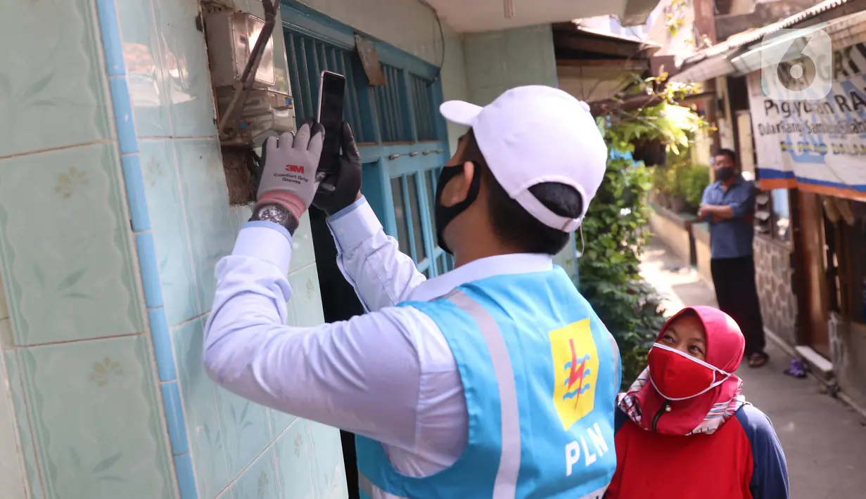 Petugas PLN berbincang dengan seorang ibu saat melakukan pencatatan meteran listrik di rumah warga kawasan Kebayoran Baru, Jakarta, Selasa (30/6/2020). Pengerahan petugas dilakukan untuk memastikan kesesuaian antara tagihan rekening listrik pelanggan dengan penggunaannya. (Liputan6.com/Angga Yuniar)
