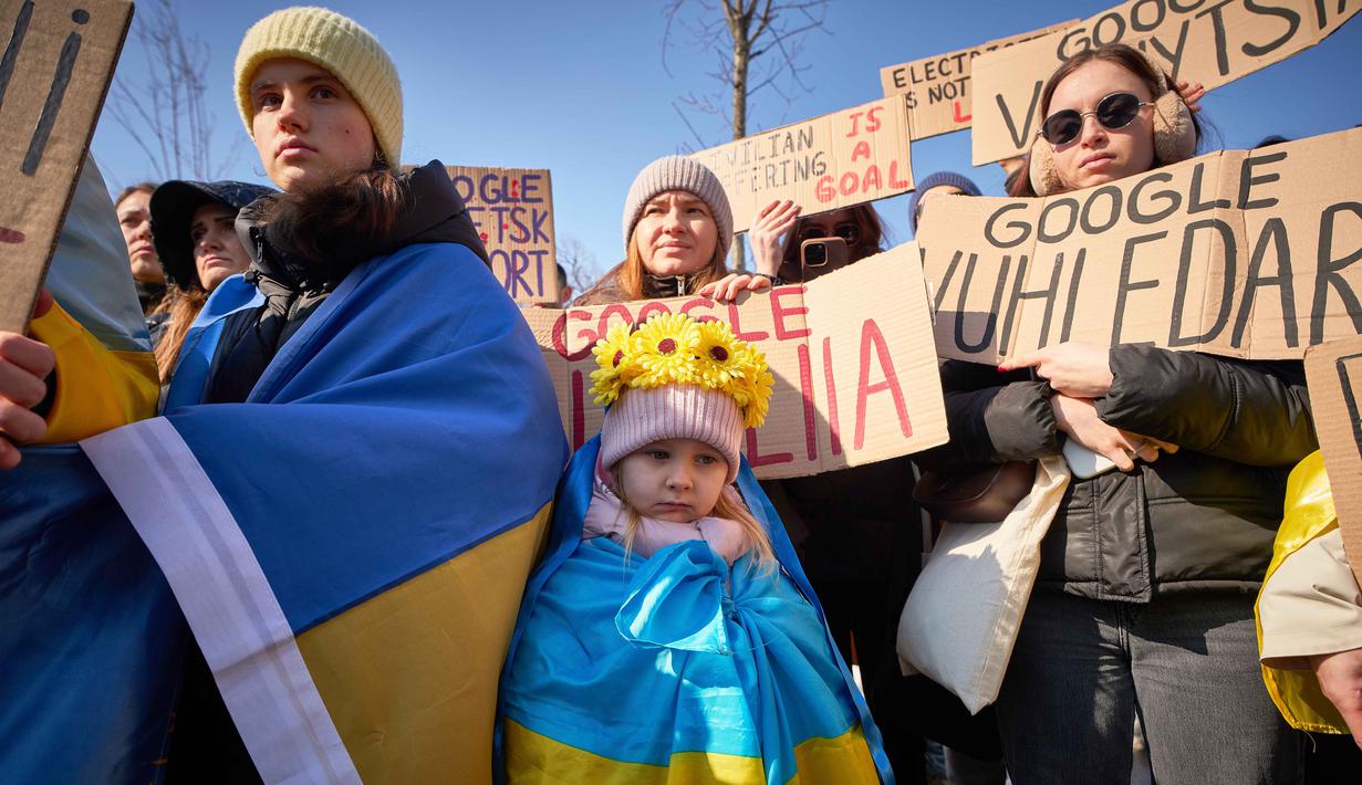 Unjuk rasa menandai tahun keempat sejak dimulainya invasi skala penuh Rusia ke Ukraina yang terjadi pada 24 Februari 2022. Tampak dalam foto, orang-orang memegang spanduk saat anggota komunitas Ukraina menggelar protes untuk menandai tahun keempat sejak dimulainya invasi skala penuh Rusia ke Ukraina di Bukares, Rumania, Minggu 22 Februari 2026. (AP Photo/Vadim Ghirda)