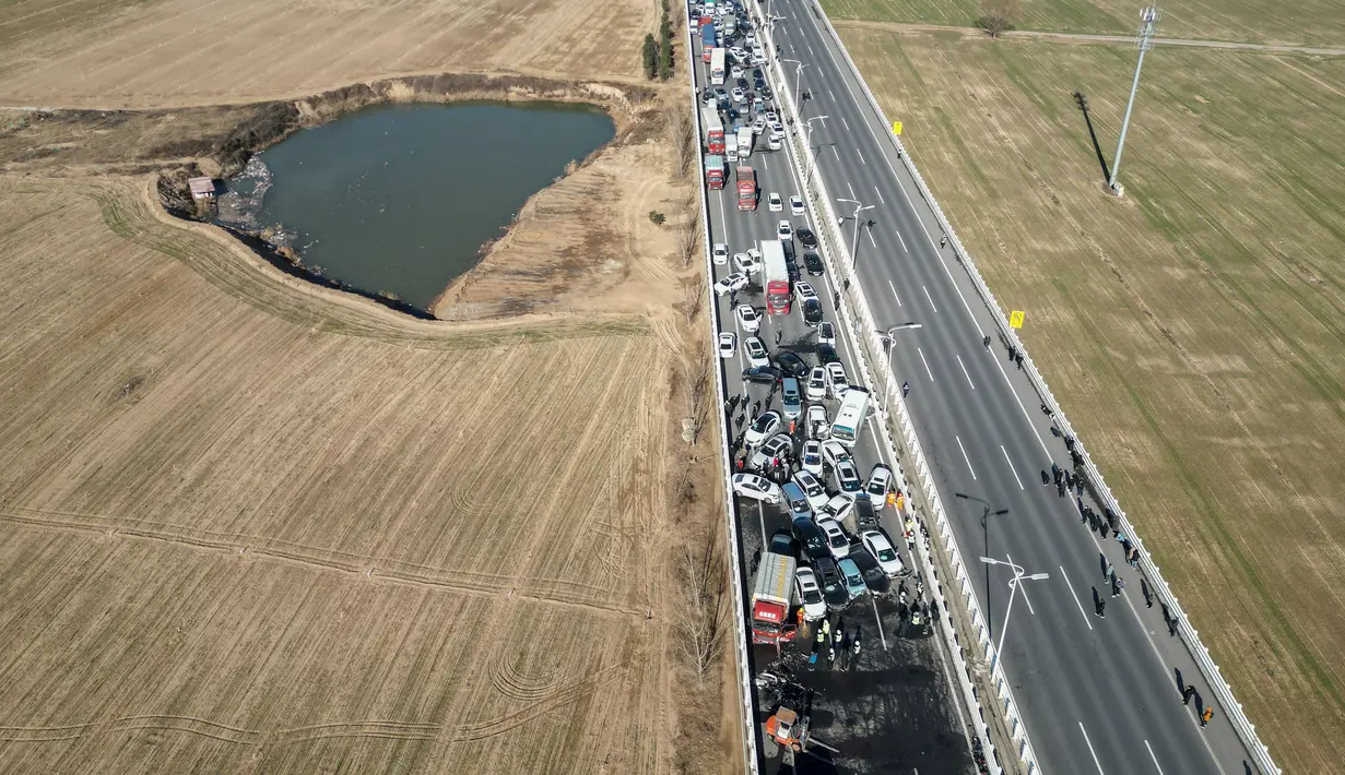 Foto udara menunjukkan tabrakan beberapa kendaraan di Jembatan Sungai Kuning Zhengxin di Zhengzhou, di provinsi Henan tengah China pada 28 Desember 2022. Banyak orang terluka dan terjebak di lokasi kecelakaan dan pemadam kebakaran sudah berada di jembatan itu. (AFP/STR)