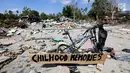 Sebuah papan dengan pesan Childhood Memories terpasang di sepeda di atas reruntuhan puing pasca gempa bumi dan tsunami di Jalan Trans Sulawesi, Palu, Sulawesi Tengah, Kamis (4/10). (Liputan6.com/Fery Pradolo)