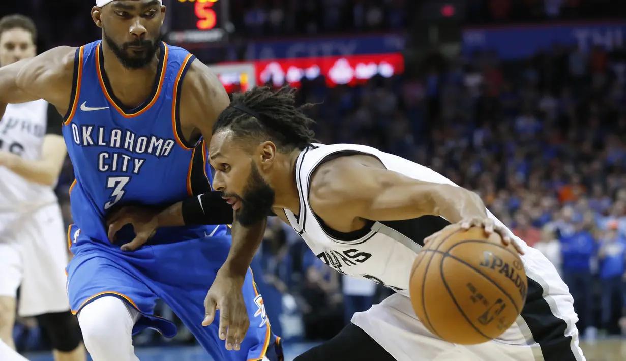 Pebasket San Antonio Spurs, Patty Millsi, berusaha melewati pebasket Oklahoma City Thunder, Corey Brewer, pada laga NBA di Chesapeake Energy Arena, Minggu (11/3/2018). Thunder menang 104-94 atas Spurs. (AP/Sue Ogrocki)