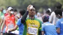 Seorang pelari mengguyur wajahnya dengan air saat mengikuti Mandiri Jakarta Marathon. (Bola.com/Vitalis Yogi Trisna)