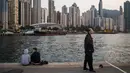 Orang-orang bersantai di dermaga umum di sebelah Pelabuhan Victoria di Hong Kong (3/3). Pemandangan yang spektakuler membuat pelabuhan ini menjadi daya tarik wisata utama Hong Kong. (AFP Photo/Dale De La Rey)