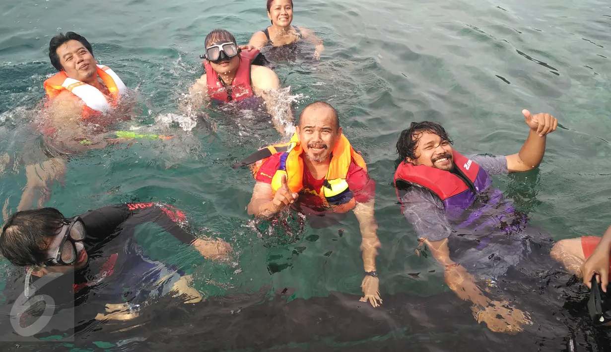 Pengunjung menikmati laut jernih Pulau Arborek Raja Ampat, Papua Barat. Pulau Arborek merupakan salah satu tempat snorkeling yang kaya akan kekayaan bawah laut. (Liputan6.com/Zulfi Suhendra)