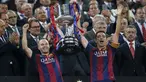 Gelandang Barcelona, Xavi Hernandes (kiri) dan Andres Iniesta mengangkat trofi Copa del Rey usai memenangkan Final Piala Raja di Nou Camp, Spanyol (31/5/2015). Barcelona berhasil menaklukkan Bilbao dengan skor akhir 3-1. (Reuters/Albert Gea)
