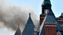 Asap hitam terlihat membubung dari atap Hotel Mandarin Oriental yang mengalami kebakaran di London, Inggris, Rabu (6/6). Menurut pihak pemadam kebakaran hingga saat ini belum diketahui penyebab kebakaran tersebut. (John Stillwell/PA via AP)