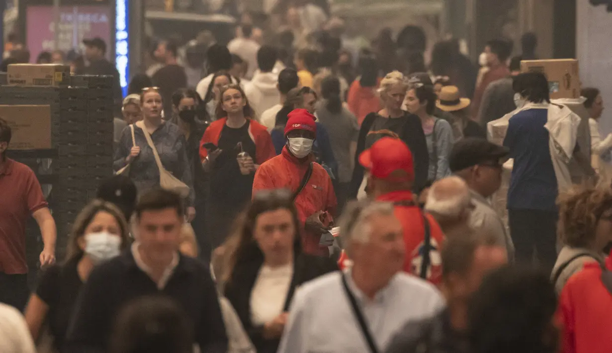 Di New York, para komuter mengambil masker era pandemi untuk menghadapi kondisi berbahaya saat para penjual masker di pinggir jalan melakukan bisnis yang laris manis dengan menjualnya kepada mereka yang kehabisan. (AP Photo/Yuki Iwamura)