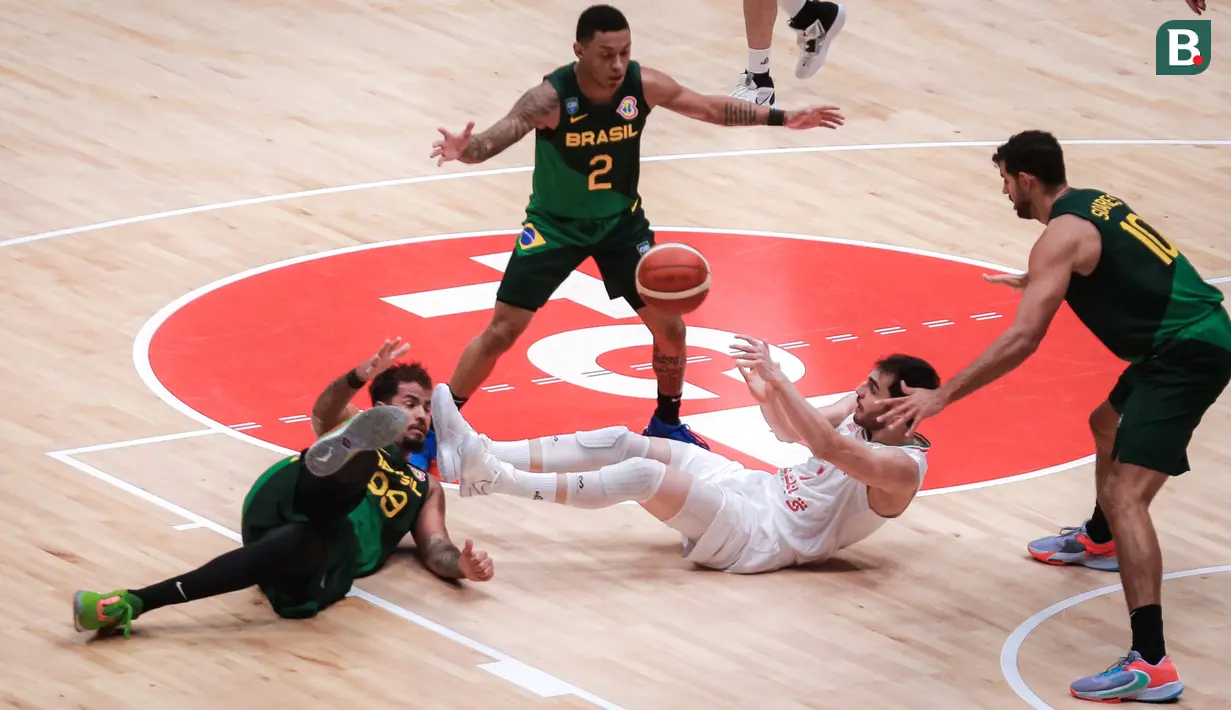 <p>Pebasket Iran, Navid Rezaeifar (tengah) terjatuh saat berebut dengan pebasket Brasil, Lucas Dias pada laga Grup G Piala Dunia FIBA 2023 antara Timnas Basket Iran menghadapi Brasil di Indonesia Arena, Senayan, Jakarta, Sabtu (26/08/2023). (Bola.com/Bagaskara Lazuardi)</p>