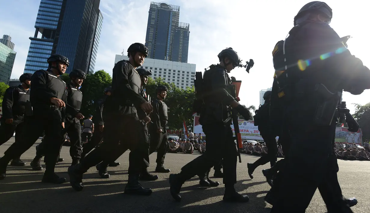 Aparat kepolisian bersiap mengikuti Apel Operasi Lilin 2018 di lapangan Polda Metro Jaya, Jakarta, Jumat (21/12). Operasi digelar dalam rangka pengamanan Natal 2018 dan Tahun Baru 2019. (Merdeka.com/Imam Buhori)