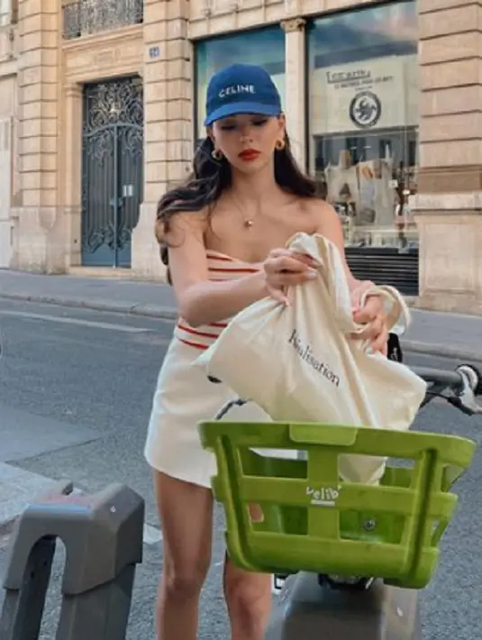 Street syle yang kental dengan nuansa musim panas terlihat pada penampilan Alyssa dalam foto ini. Ia mengenakan off-the-shoulder crop top bercorak garis merah-putih, dipadunya dengan mini skirt putih. Ia juga menambahkan topi Celine berwarna biru sebagai pemanis pada keseluruhan penampilannya. Foto: Instagram.