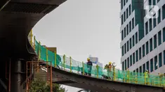 Pekerja menyelesaikan pengerjaan jembatan penyeberangan orang (JPO) dan jembatan penyeberangan sepeda di Karet Sudirman, Jakarta, Jumat (8/10/2021). JPO yang akan dilengkapi jalur sepeda dan terintegrasi dengan halte Transjakarta itu akan rampung pada November 2021. (Liputan6.com/Johan Tallo)