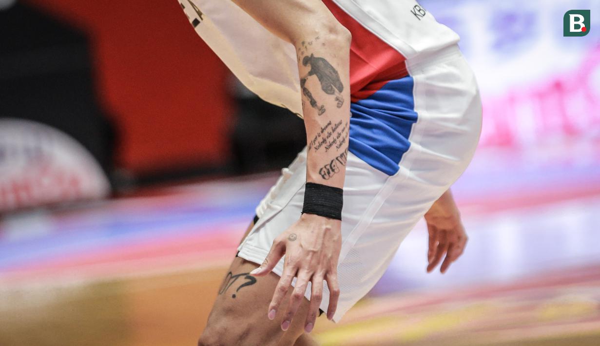 Tato bergambar karakter anime One Piece, Portgas D. Ace (kanan) yang sedang memegang kepala adiknya, Monkey D. Luffy saat matchday kedua Grup B FIBA Asia Cup 2022 melawan Timnas Basket Taiwan di Istora Senayan, Jakarta, Kamis (14/07/2022). (Bola.com/Bagaskara Lazuardi)