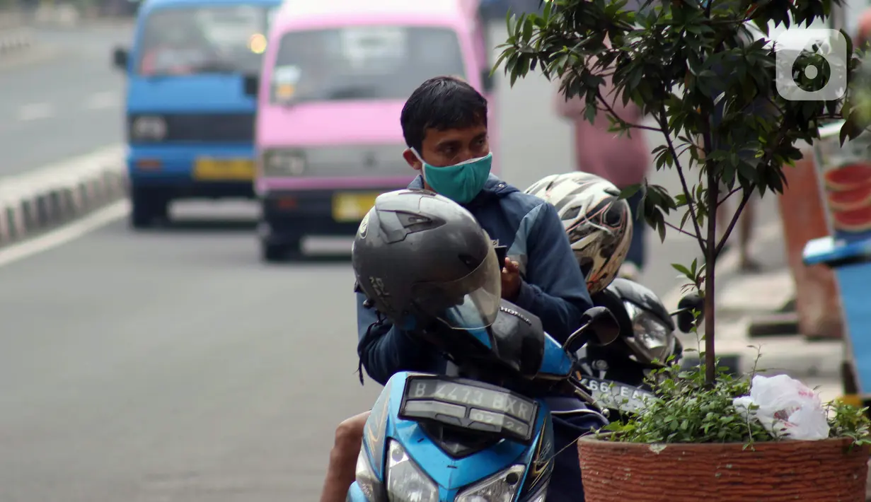 Pengendara motor beristirahat di Jalan Margonda Raya, Depok, Jawa Barat, Minggu (12/4/2020). Menteri Kesehatan menyetujui menerapkan Pembatasan Sosial Berskala Besar (PSBB) di wilayah Kota Depok yang akan dimulai, Rabu (15/4) dalam pencegahan meluasnya COVID-19. (Liputan6.com/Helmi Fithriansyah)