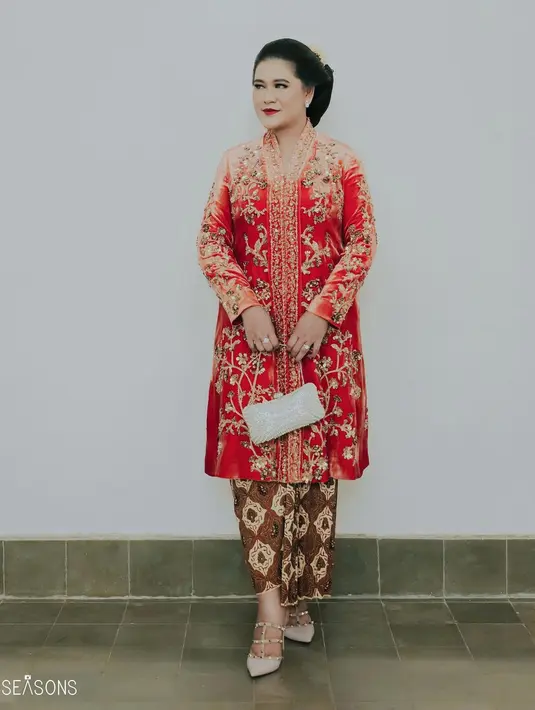 Kali ini tak bisa dipungkiri pesona perempuan Jawa yang kental dari Kahiyang ketika melihatnya mengenakan kebaya. Atasan kebaya panjang berwarna merah ini juga merupakan rancangan Biyan. Cantik dengan motif payet-payet berwarna emas yang gemerlap, Kahiyang memadukan penampilannya ini dengan kain batik sebagai bawahan. Foto: Instagram.