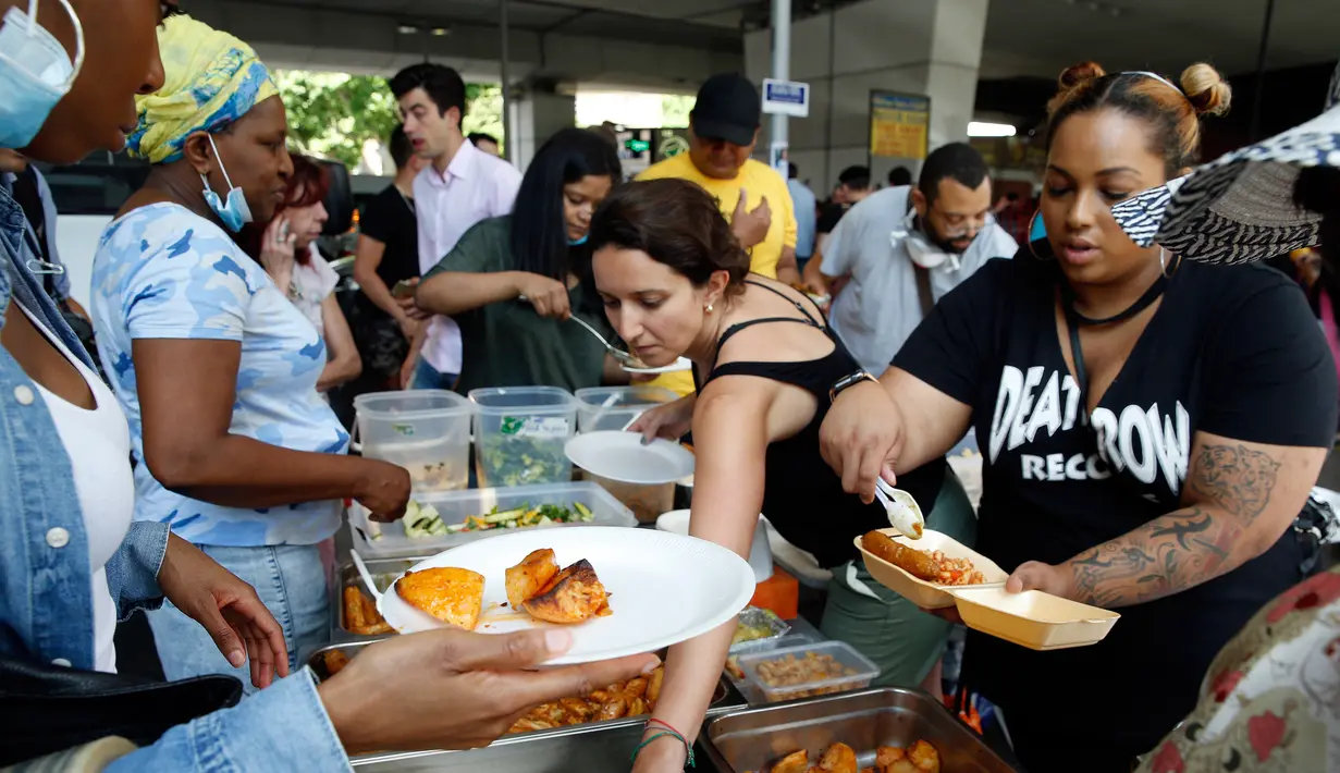 Makanan yang disajikan untuk para korban kebakaran apartemen di Kensington, London, (15/6). Korban jiwa akibat kebakaran di apartemen berlantai 24 di London mencapai 12 orang. (AP Photo/Alastair Grant)