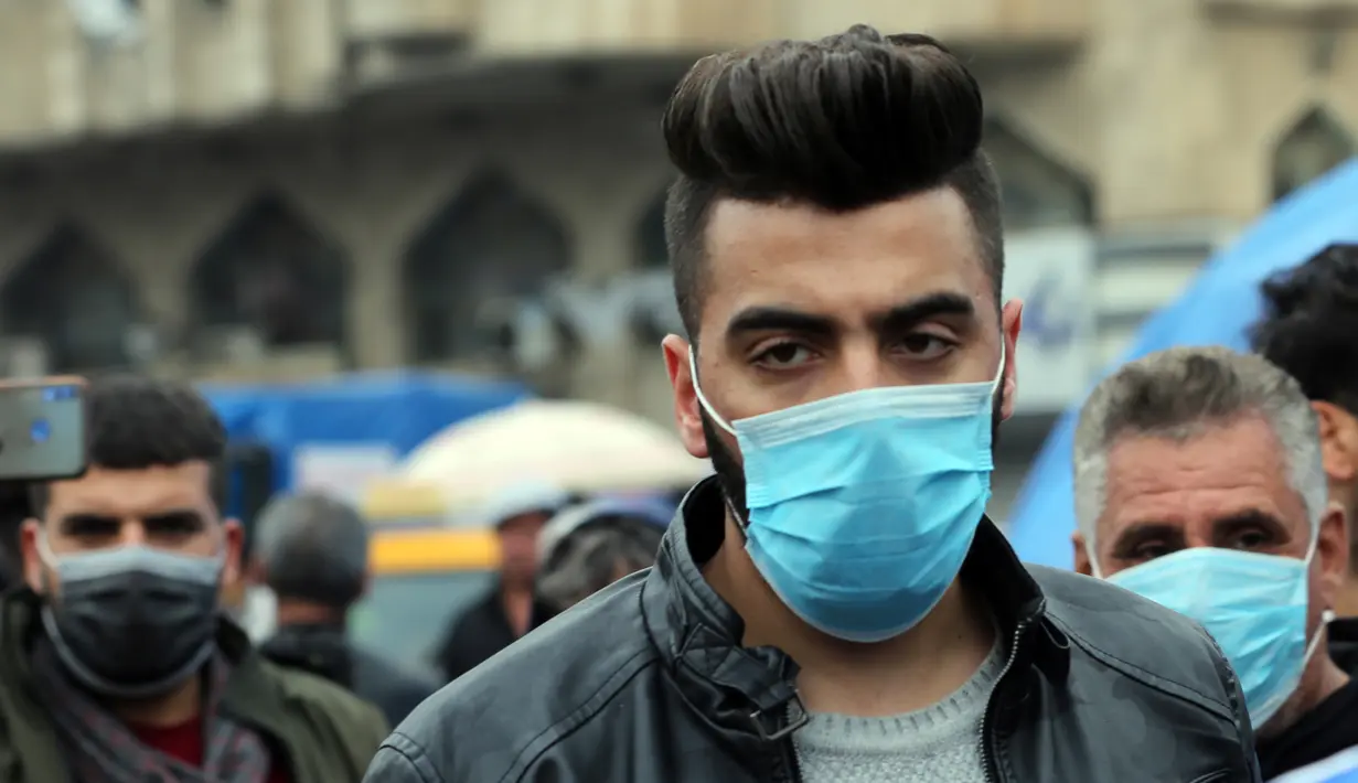 Seorang pria mengenakan masker di sebuah jalan di Baghdad, Irak, (25/2/2020). Irak mengumumkan empat kasus baru COVID-19 di Provinsi Kirkuk, wilayah utara, pada Selasa (25/2), sehingga total pasien terinfeksi di negara itu bertambah menjadi lima orang. (Xinhua/Khalil Dawood)