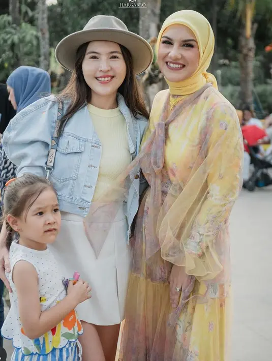 Olivia Jensen mengenakan outer denim dipadukan inner kuning dan mini skirt putih. Tampil dengan topinya. [@_irishbella_]