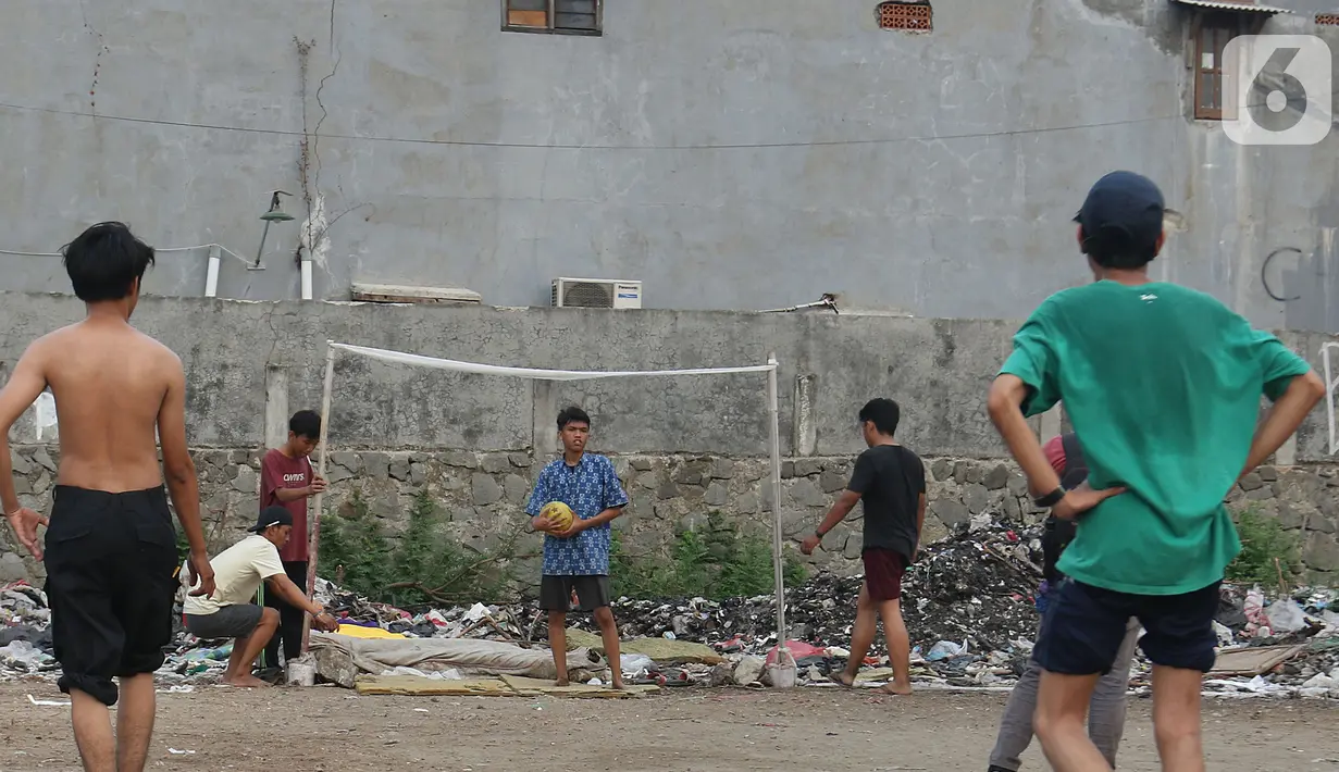 Sejumlah warga bermain sepak bola di antara tumpukan sampah di kawasan Penjaringan, Jakarta, Jumat (1/11/2019). Minimnya lahan bermain di Jakarta membuat warga bermain sepak bola di sekitar tumpukan sampah. (Liputan6.com/Herman Zakharia)