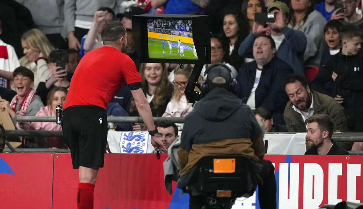 Wasit Andreas Ekberg memeriksa VAR sebelum memberikan penalti kepada Inggris saat melawan Swiss pada pertandingan uji coba di Stadion Wembley, London, Inggris, 26 Maret 2022. Inggris menang 2-1. (AP Photo/Alastair Grant)