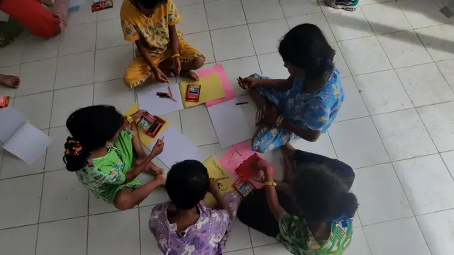 Anak-anak imigran Rohingya sedang menggambar. Foto diambil di lokasi penampungan imigran di Lhokseumawe pada Desember 2022. (Liputan6.com/Rino Abonita)
