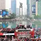Sejumlah suporter melakukan perayaan bersama pemain Timnas Indonesia U-22 saat mengikuti parade perayaan kesuksesan Timnas Indonesia U-22 di SEA Games 2023 Kamboja di Bundaran Hotel Indonesia, Jakarta, Jumat (19/05/2023). (Bola.com/M Iqbal Ichsan)